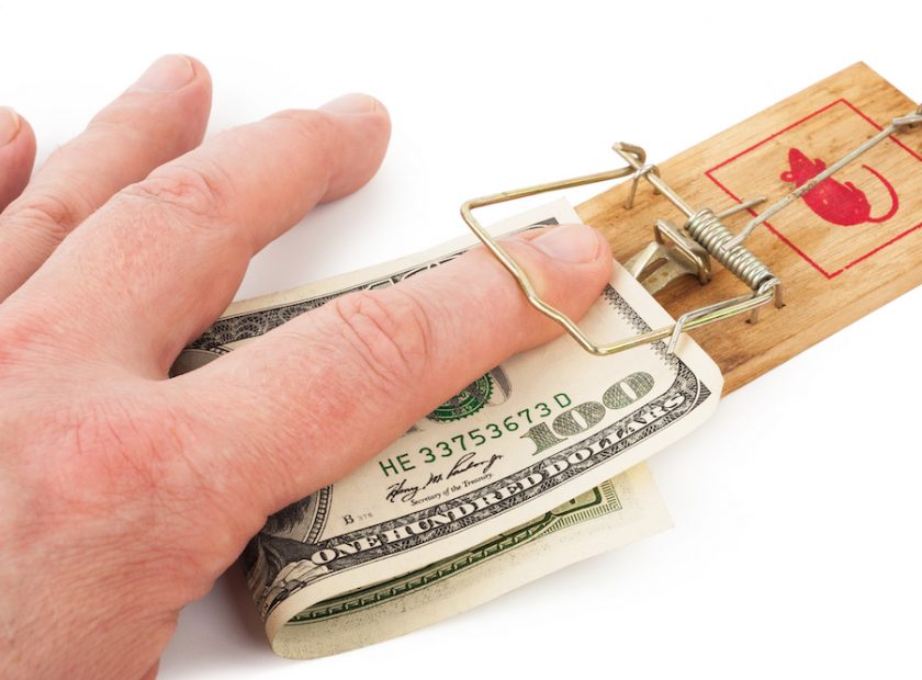 Hand and mousetrap with money