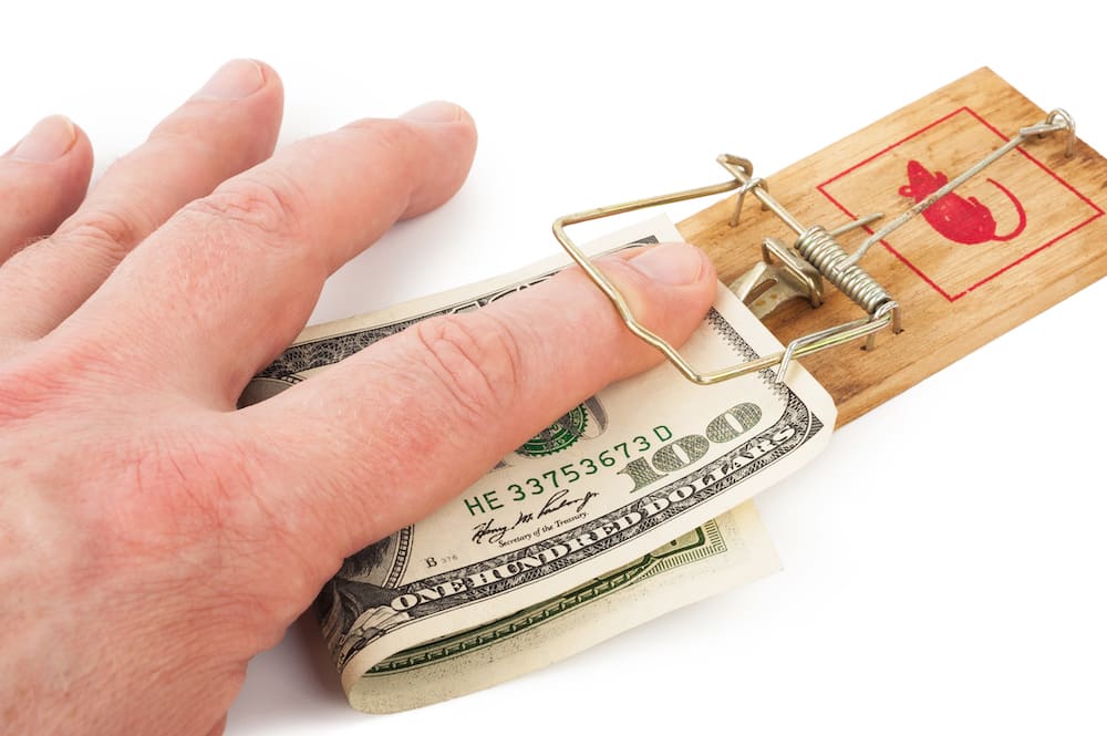 Hand and mousetrap with money