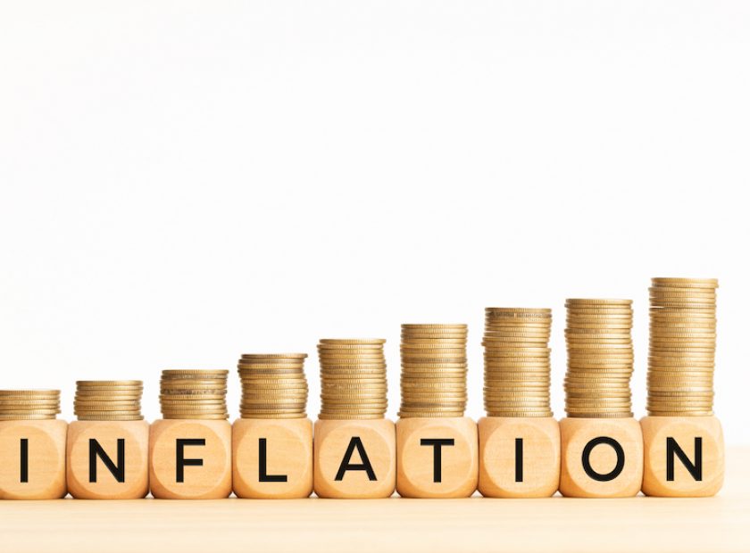 Inflation concept. Text on wooden blocks and stacked coins. Copy space