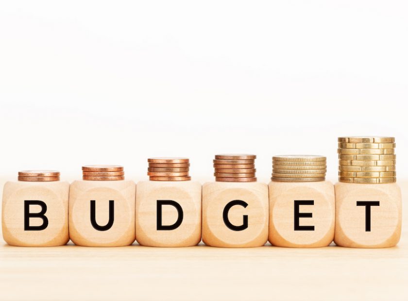 Budget word on wooden blocks and coins on table