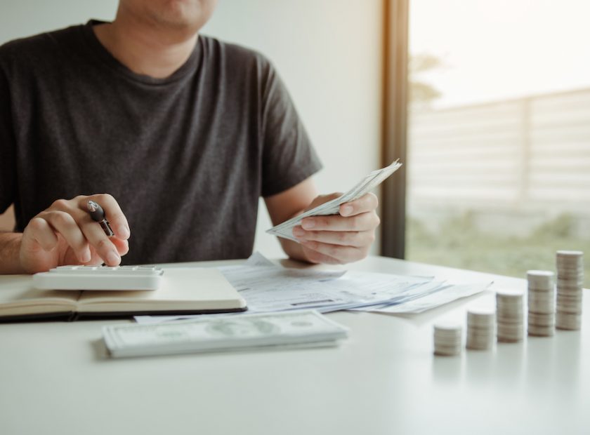 Man use calculators and documents that calculate expenses in the home office.