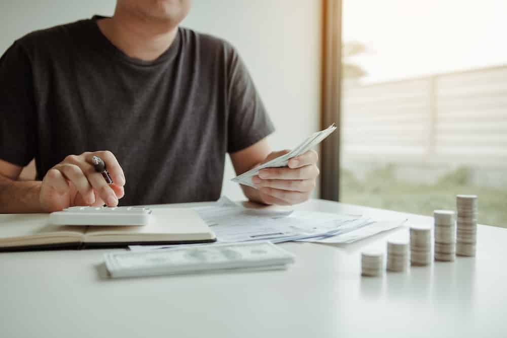 Man use calculators and documents that calculate expenses in the home office.