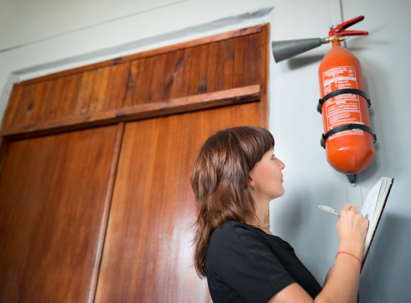 Young woman fire inspector writes in office