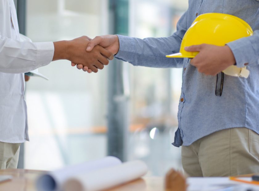 Architects and contractors shake hands to work.