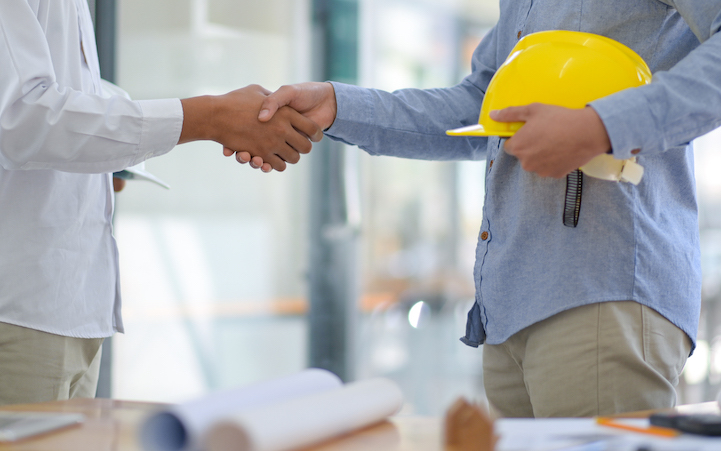 Architects and contractors shake hands to work.