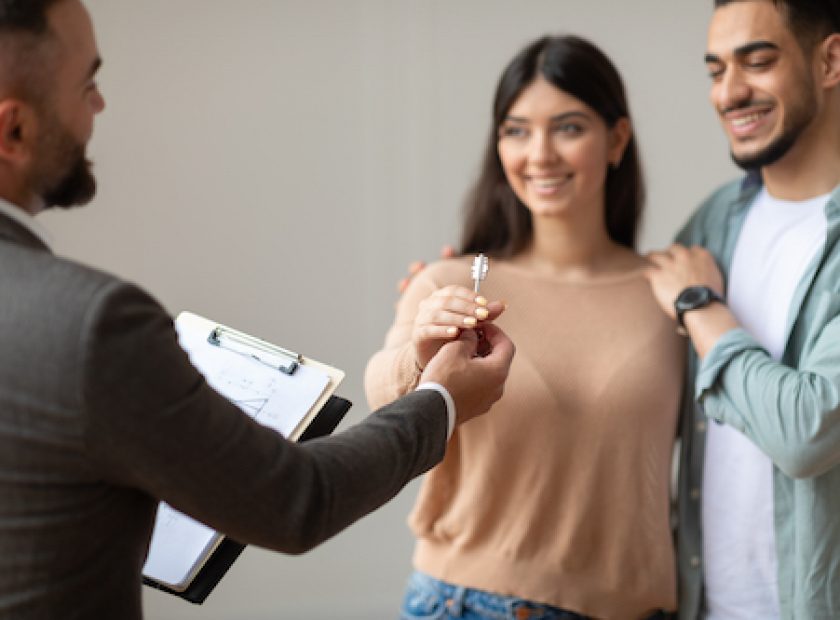 Real Estate Agent Giving Keys To Excited Buyers