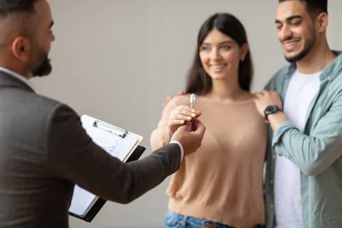 Real Estate Agent Giving Keys To Excited Buyers