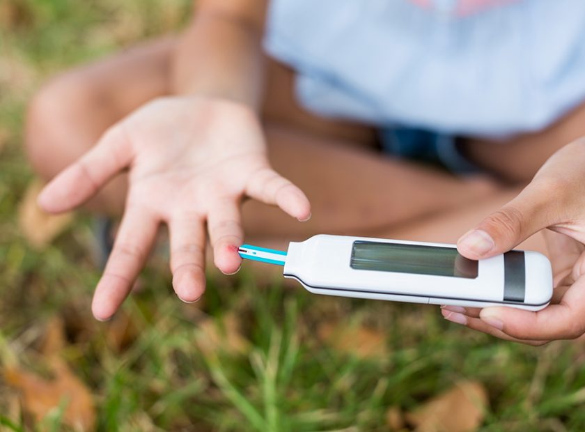 Girl testing diabetes on glucose meter